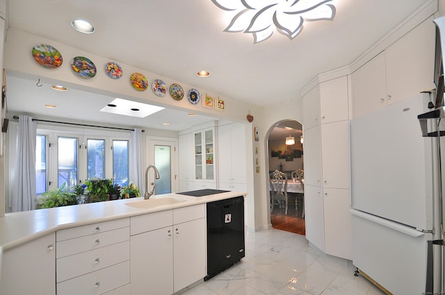 kitchen featuring dishwasher, white refrigerator, white cabinetry, and sink