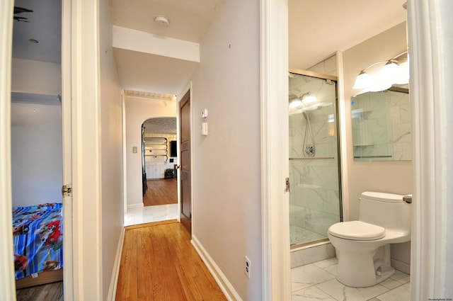 bathroom featuring toilet and an enclosed shower