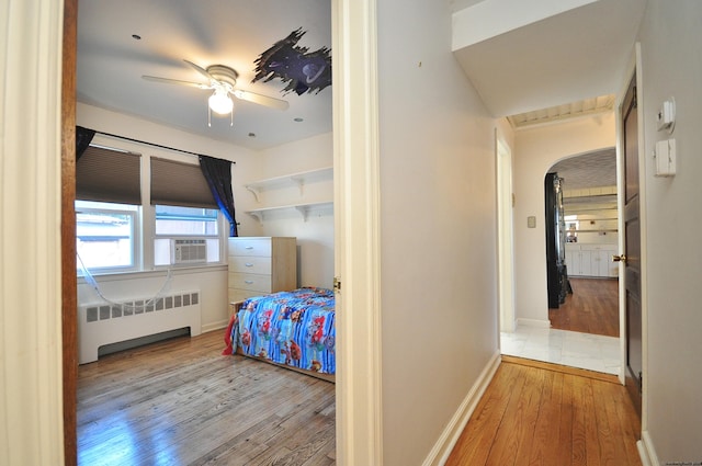 bedroom featuring radiator, ceiling fan, and light hardwood / wood-style flooring