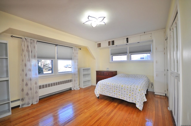 bedroom featuring hardwood / wood-style flooring and radiator heating unit