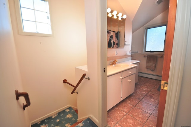 bathroom with a healthy amount of sunlight, vanity, baseboard heating, and lofted ceiling