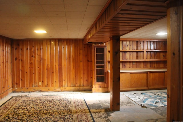 basement featuring wooden walls