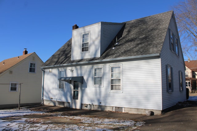 view of snow covered rear of property