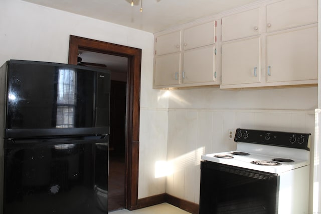 kitchen with black fridge, white cabinetry, and electric range