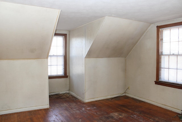 bonus room featuring dark wood-type flooring, vaulted ceiling, and plenty of natural light