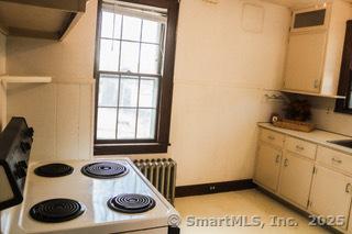 kitchen with sink, white electric range oven, and radiator