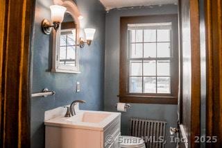 bathroom with vanity, radiator heating unit, plenty of natural light, and toilet