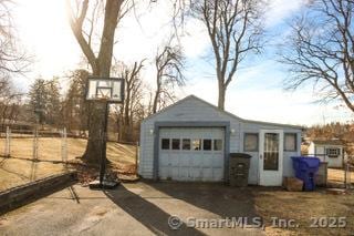 exterior space with a garage and an outbuilding