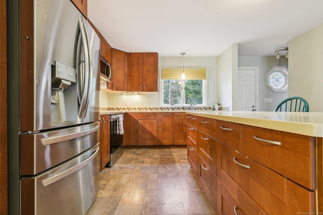 kitchen featuring sink, stainless steel appliances, and hanging light fixtures