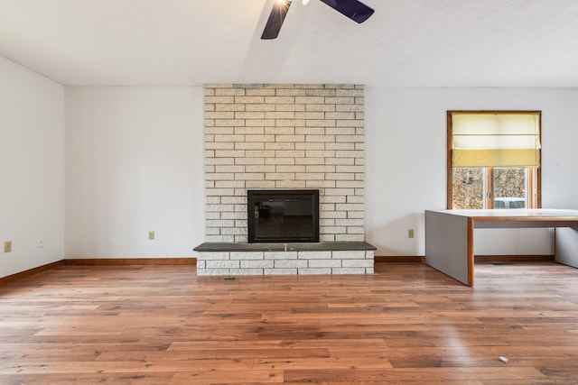 unfurnished living room featuring ceiling fan, wood-type flooring, and a fireplace
