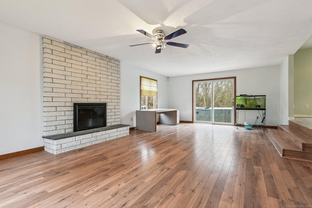 unfurnished living room with ceiling fan, a fireplace, and hardwood / wood-style floors
