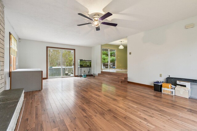 unfurnished living room featuring ceiling fan and wood-type flooring
