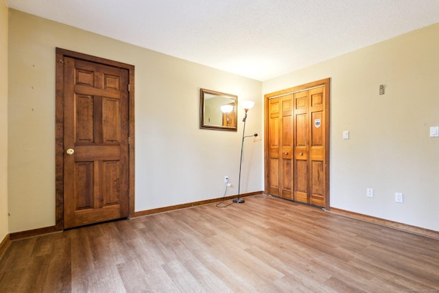 unfurnished room with a textured ceiling and light hardwood / wood-style flooring