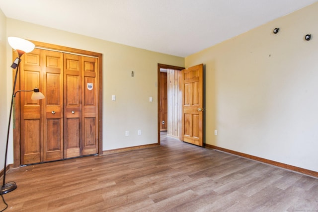 unfurnished bedroom with a closet and light hardwood / wood-style floors