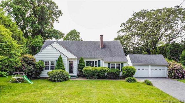 new england style home featuring a garage and a front lawn