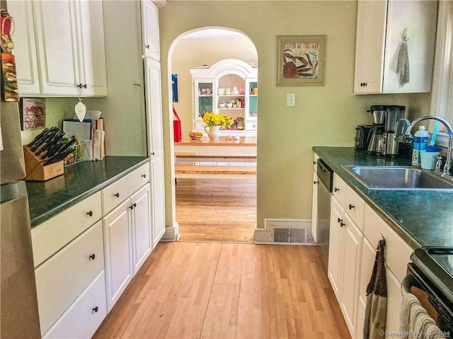 kitchen featuring sink, dishwasher, white cabinets, range, and light hardwood / wood-style floors