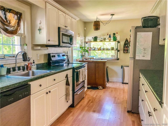 kitchen featuring sink, white cabinets, light wood-type flooring, and appliances with stainless steel finishes