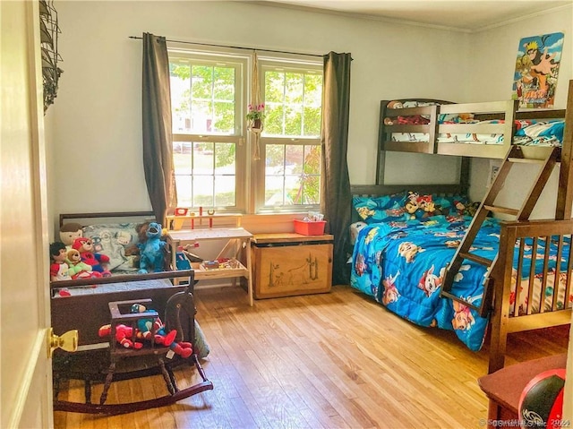 bedroom featuring wood-type flooring and ornamental molding