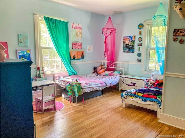 bedroom featuring multiple windows and hardwood / wood-style floors