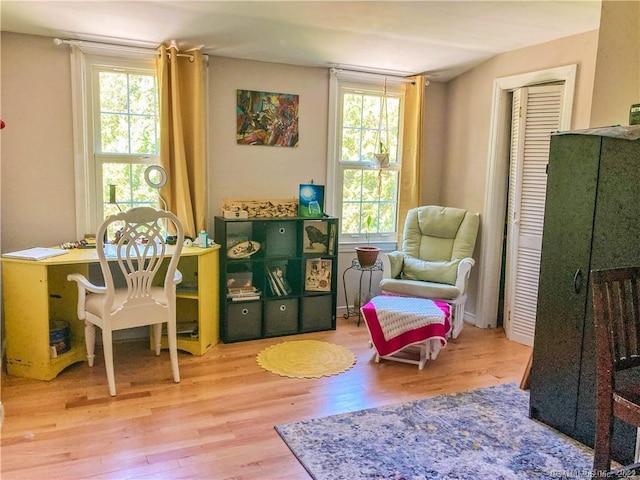 sitting room with hardwood / wood-style flooring and a healthy amount of sunlight