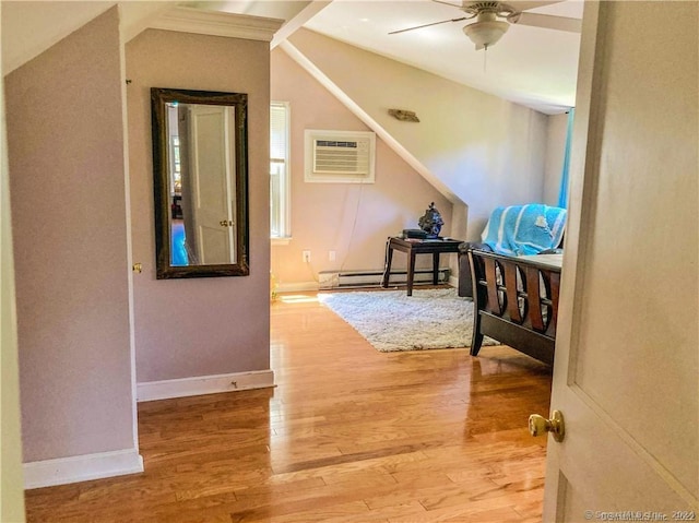 hallway featuring vaulted ceiling, a baseboard heating unit, a wall mounted air conditioner, and hardwood / wood-style flooring