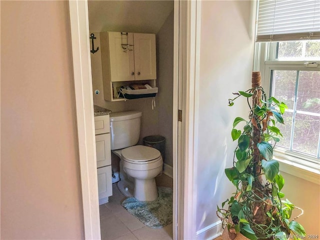 bathroom with tile patterned floors, vanity, toilet, and a wealth of natural light