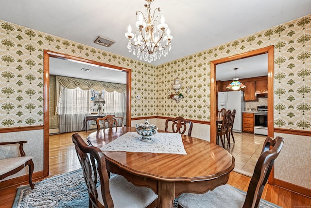 dining area featuring light wood-type flooring and a chandelier