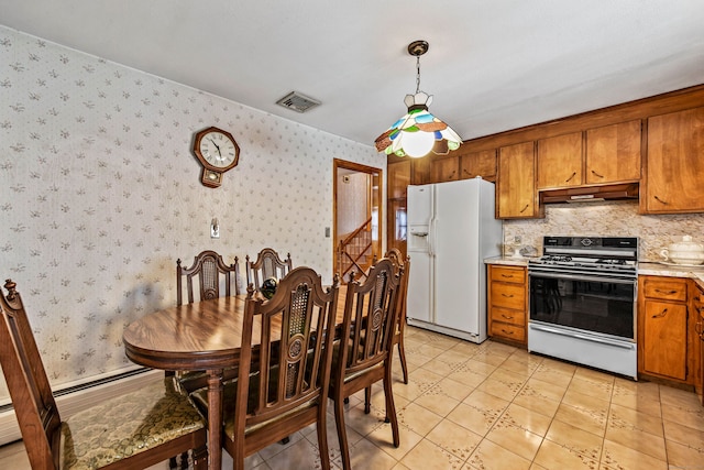 kitchen featuring light tile patterned floors, white appliances, and hanging light fixtures