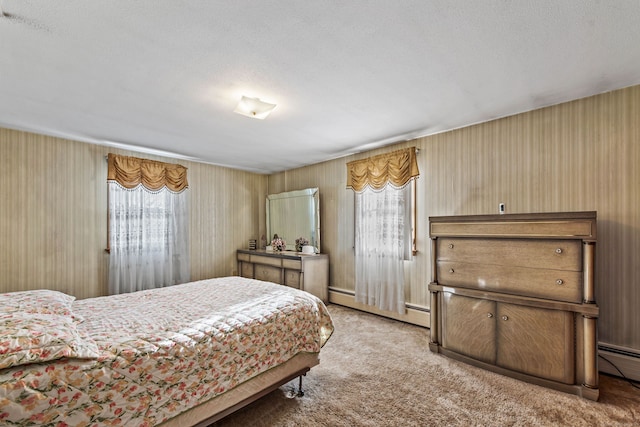 bedroom featuring carpet flooring, baseboard heating, and a textured ceiling