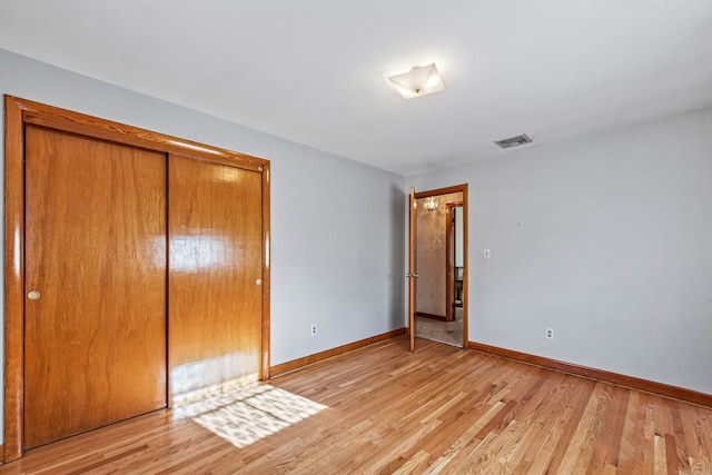 unfurnished bedroom featuring a closet and light hardwood / wood-style floors