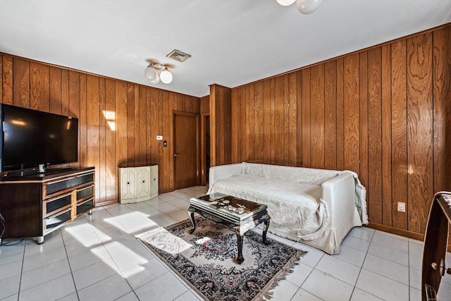 bedroom with wood walls and light tile patterned flooring