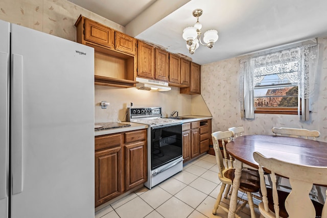 kitchen featuring a chandelier, light tile patterned floors, pendant lighting, and white appliances