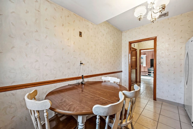 dining space with tile patterned flooring and a chandelier