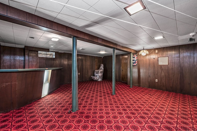 basement with bar and wooden walls