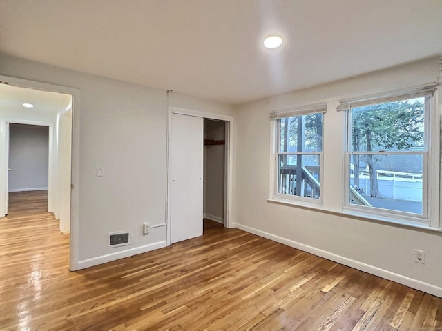 unfurnished bedroom featuring light wood-type flooring and a closet