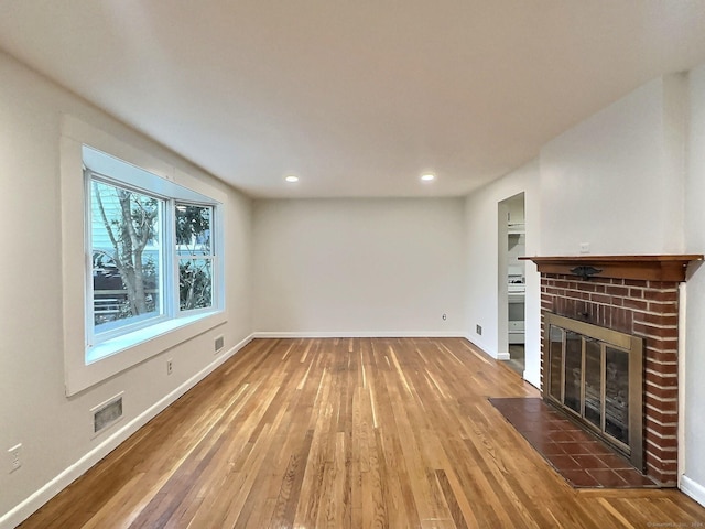 unfurnished living room featuring a fireplace and dark wood-type flooring