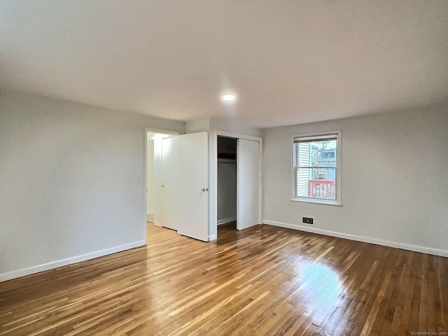 unfurnished bedroom with a closet and hardwood / wood-style flooring