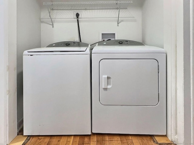 washroom with washer and dryer and light wood-type flooring