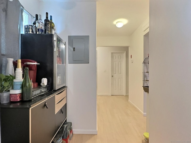 hallway featuring electric panel and light hardwood / wood-style flooring