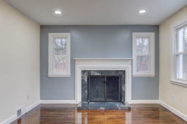 unfurnished living room with dark hardwood / wood-style flooring and a high end fireplace