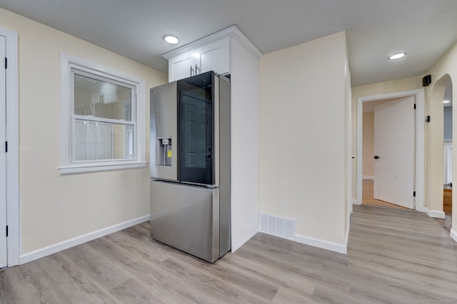 kitchen with white cabinetry, light hardwood / wood-style floors, and stainless steel refrigerator with ice dispenser