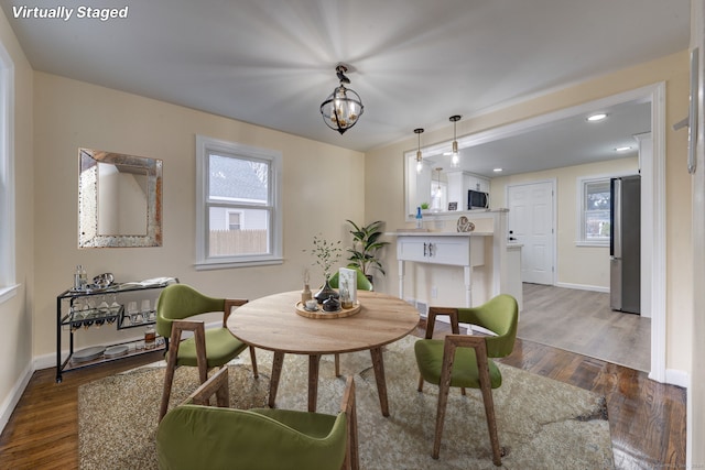 dining area featuring a chandelier, plenty of natural light, and dark wood-type flooring