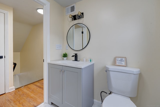 bathroom with hardwood / wood-style flooring, vanity, and toilet