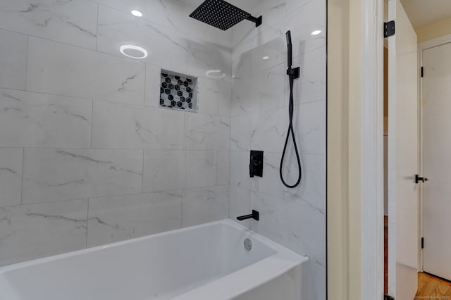 bathroom with hardwood / wood-style flooring and tiled shower / bath combo