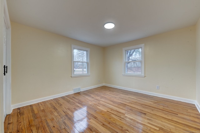 empty room featuring plenty of natural light and light hardwood / wood-style flooring