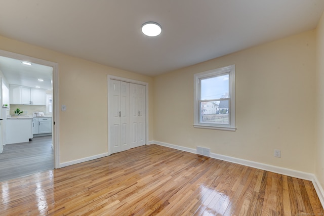 unfurnished bedroom with light hardwood / wood-style floors and a closet