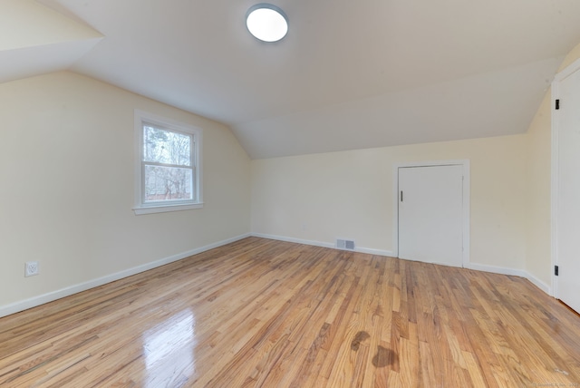 additional living space featuring light hardwood / wood-style floors and lofted ceiling