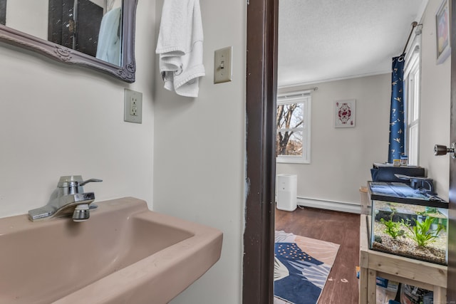 bathroom featuring sink, a textured ceiling, and a baseboard heating unit