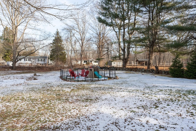 yard covered in snow featuring a playground