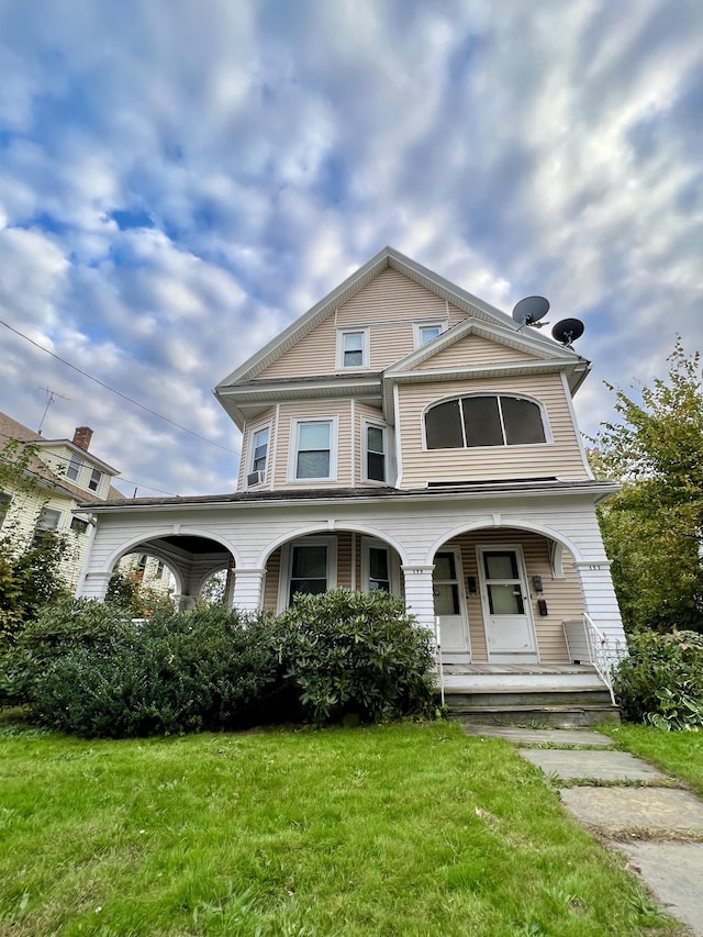 view of front of house with a porch and a front yard